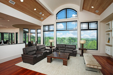 Cette image montre un grand salon design ouvert avec un mur blanc, un sol en bois brun, aucune cheminée et un téléviseur encastré.