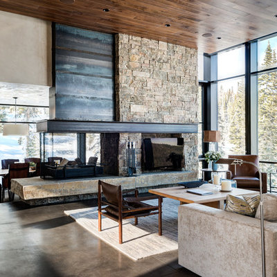 Inspiration for a huge contemporary open concept concrete floor living room remodel in Other with beige walls, a two-sided fireplace, a stone fireplace and a tv stand