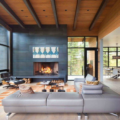 Inspiration for a large rustic open concept light wood floor living room remodel in Other with black walls, a stone fireplace and no tv