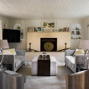 This is an example of a small mediterranean living room in Berkshire with beige walls, carpet, grey floors, a standard fireplace and a wall mounted tv.