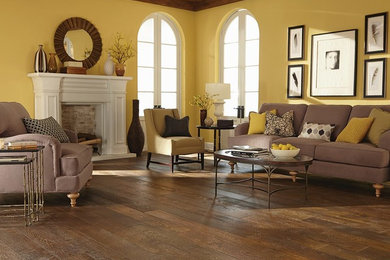 Modelo de salón abierto tradicional renovado de tamaño medio con paredes amarillas y suelo de madera en tonos medios