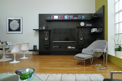 Foto de salón abierto minimalista de tamaño medio con paredes multicolor, suelo de madera clara y pared multimedia