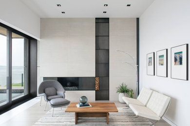 Photo of a modern living room in Seattle with white walls, a standard fireplace and grey floors.