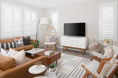Aménagement d'un salon classique avec un mur gris, un sol en bois brun, un téléviseur indépendant et un sol marron.
