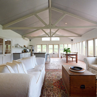 Diseño de salón abierto, de estilo de casa de campo, grande, con suelo de ladrillo
