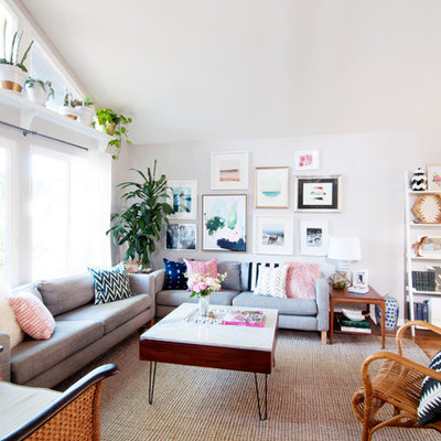 Example of an eclectic open concept medium tone wood floor living room library design in Los Angeles with no fireplace, no tv and white walls