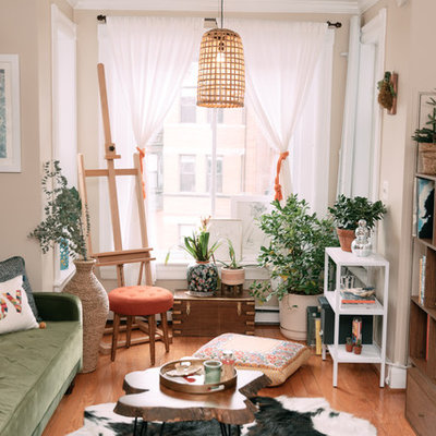Example of an eclectic medium tone wood floor and brown floor living room design in DC Metro with beige walls and a tv stand
