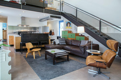 Inspiration for an industrial loft-style concrete floor and gray floor living room remodel in Other with white walls