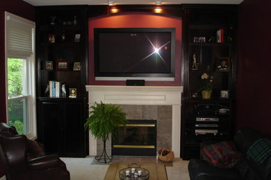 Living room - living room idea in Detroit with black walls, a standard fireplace, a wall-mounted tv and a stone fireplace