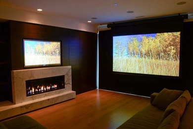 Example of a medium tone wood floor home theater design in Vancouver with a wall-mounted tv