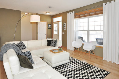 Foto de salón abierto contemporáneo de tamaño medio con paredes verdes, suelo laminado y televisor independiente