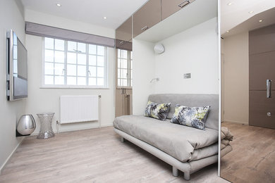 Ejemplo de salón abierto actual pequeño con paredes beige, suelo vinílico, televisor colgado en la pared y suelo beige