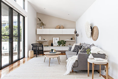 Foto di un soggiorno stile marino di medie dimensioni e aperto con pareti bianche, pavimento in legno massello medio e pavimento marrone