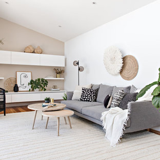 Inspiration for a mid-sized beach style open concept living room in Sydney with no fireplace, white walls, medium hardwood floors and brown floor.