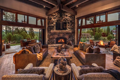 Photo of a rustic open plan living room in Sacramento with brown walls, dark hardwood flooring, a corner fireplace, a stone fireplace surround and a wall mounted tv.