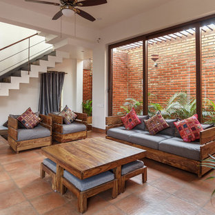 Repräsentatives Asiatisches Wohnzimmer mit weißer Wandfarbe, braunem Boden und Backsteinboden in Bangalore