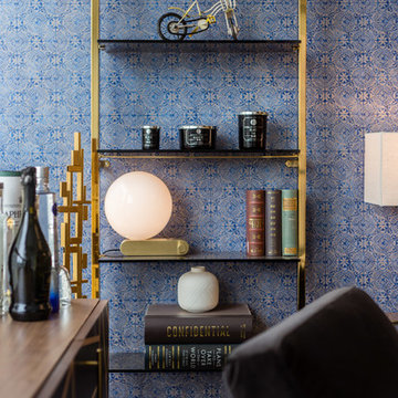 Navy blue wallpaper and brass shelves