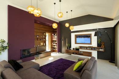 Diseño de salón actual con paredes púrpuras, chimenea de esquina y pared multimedia