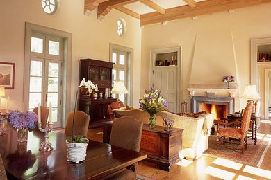 Large elegant medium tone wood floor living room photo in New York with a stone fireplace, beige walls, a standard fireplace and a concealed tv