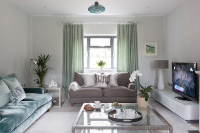 Photo of a medium sized modern formal and grey and teal enclosed living room in Kent with grey walls, carpet and a freestanding tv.