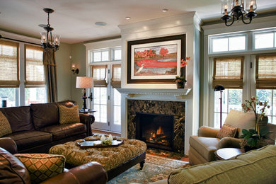 This is an example of a medium sized classic formal enclosed living room in Philadelphia with green walls, a standard fireplace, a stone fireplace surround, a freestanding tv and medium hardwood flooring.