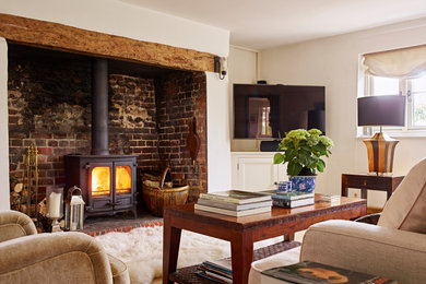 Example of a mountain style living room design in Hampshire with white walls, a wood stove and a tv stand
