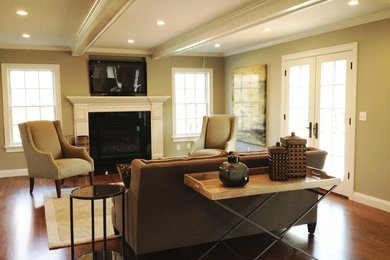 Mid-sized transitional open concept medium tone wood floor and brown floor living room photo in Boston with brown walls, a standard fireplace, a wood fireplace surround and a wall-mounted tv