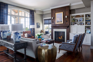 Идея дизайна: открытая гостиная комната в стиле неоклассика (современная классика) с серыми стенами, темным паркетным полом, стандартным камином, коричневым полом и синими шторами