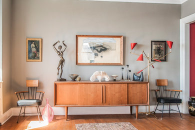 Eklektisches Wohnzimmer mit grauer Wandfarbe und braunem Holzboden in New York