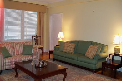 Large elegant formal and enclosed medium tone wood floor and brown floor living room photo in New York with yellow walls, a standard fireplace, a plaster fireplace and a media wall