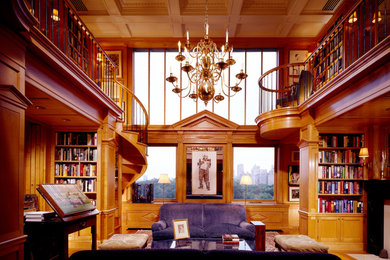 Ejemplo de biblioteca en casa abierta tradicional extra grande sin televisor con paredes marrones y suelo de madera clara