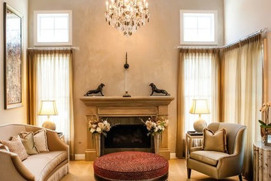 Example of a mid-sized transitional formal carpeted living room design in Orange County with beige walls, a standard fireplace and a plaster fireplace
