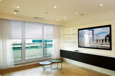 Ejemplo de salón cerrado actual de tamaño medio con paredes blancas, suelo de madera en tonos medios, pared multimedia y suelo marrón