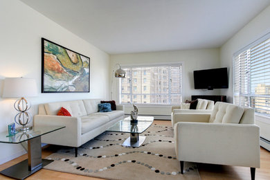 Imagen de salón para visitas cerrado clásico renovado de tamaño medio sin chimenea con paredes beige, suelo de madera clara y televisor colgado en la pared