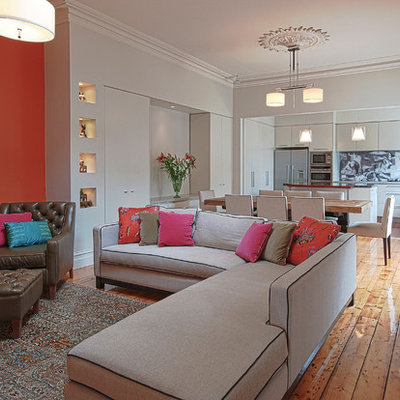 Large trendy open concept medium tone wood floor living room photo in Melbourne with orange walls