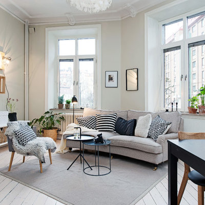 Example of a large danish formal painted wood floor living room design in Gothenburg with a wall-mounted tv and beige walls