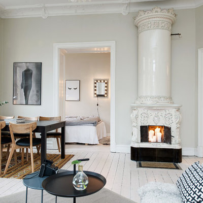 Large danish formal painted wood floor living room photo in Gothenburg with beige walls and a wood stove