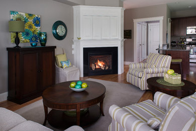 Kleines, Offenes Modernes Wohnzimmer mit brauner Wandfarbe, braunem Holzboden, Eckkamin, Kaminumrandung aus Stein, verstecktem TV und braunem Boden in Boston