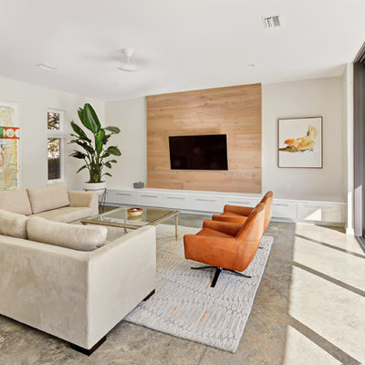 Example of a large minimalist enclosed gray floor and concrete floor living room design in Jacksonville with white walls, a wall-mounted tv and no fireplace