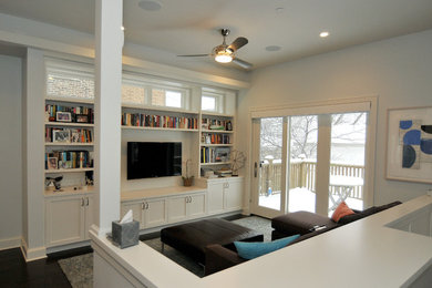 Exempel på ett modernt allrum med öppen planlösning, med vita väggar, mörkt trägolv och en väggmonterad TV
