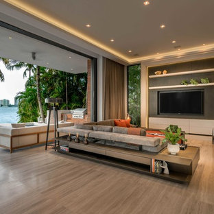 Esempio di un ampio soggiorno design aperto con pareti grigie, TV a parete, pavimento in gres porcellanato, nessun camino e pavimento beige