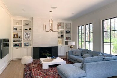 Mid-sized eclectic open concept light wood floor living room photo in Raleigh with white walls, a standard fireplace, a tile fireplace and a wall-mounted tv