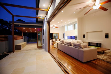 Foto de salón moderno grande con paredes blancas y suelo de madera en tonos medios