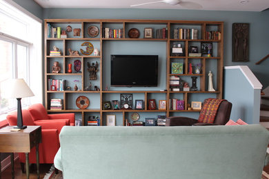 Inspiration for a mid-sized transitional open concept medium tone wood floor living room library remodel in Chicago with blue walls, a wall-mounted tv and no fireplace