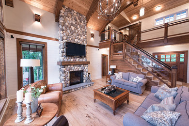 Living room - traditional living room idea in Vancouver with a standard fireplace, a stone fireplace and a wall-mounted tv