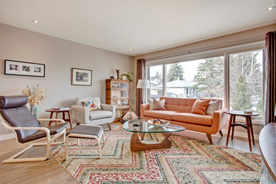 Repräsentatives Modernes Wohnzimmer mit bunten Wänden, hellem Holzboden und beigem Boden in Calgary
