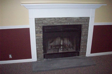 ブリッジポートにあるおしゃれなリビング (赤い壁、カーペット敷き、標準型暖炉、石材の暖炉まわり、壁掛け型テレビ) の写真