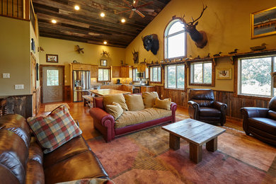 Modelo de salón abierto rural con paredes beige y suelo de madera en tonos medios
