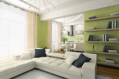 Modelo de salón abierto contemporáneo pequeño con paredes verdes, suelo de madera clara y televisor colgado en la pared