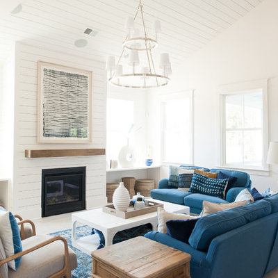 Inspiration for a coastal medium tone wood floor and brown floor living room remodel in Charleston with white walls and a standard fireplace